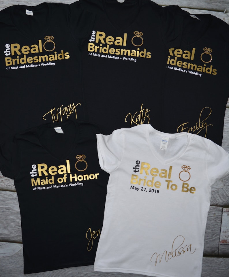 May include: Five black t-shirts with gold text and a gold ring design. The shirts say "the Real Bridesmaids of Matt and Melissa's Wedding", "the Real Maid of Honor of Matt and Melissa's Wedding", "the Real Bride To Be May 27, 2018", and "real idesmaids and Melissa's Wedding".
