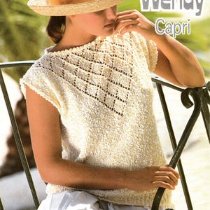 May include: A woman wearing a straw hat with a yellow ribbon and a cream-colored knitted top with a diamond pattern. The image includes the text "Wendy Capri". The top measures 30-40 inches.