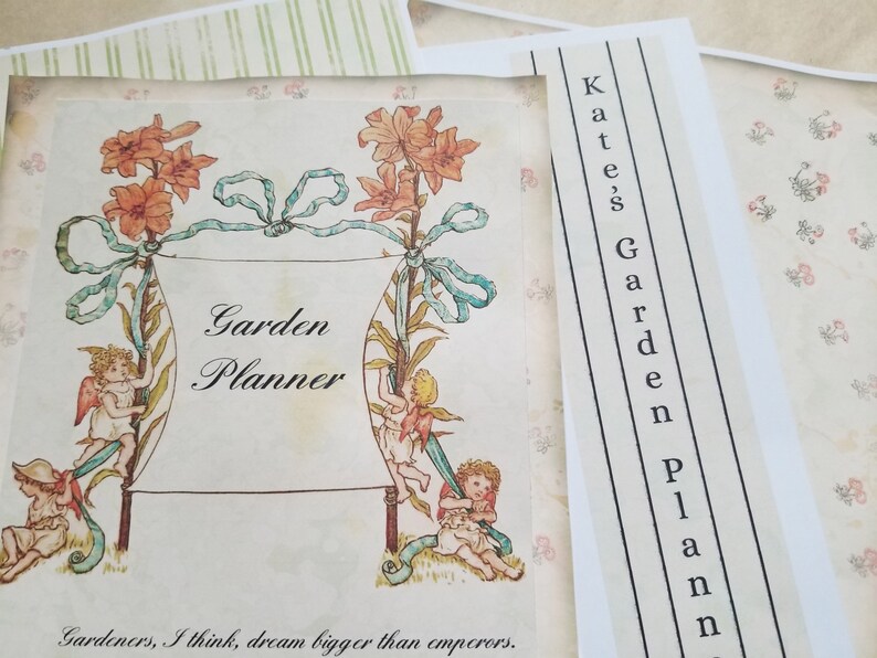 Pode incluir: Um planejador de jardim em estilo vintage com as palavras "Garden Planner" em escrita elegante. A capa apresenta ilustra&ccedil;&otilde;es florais, querubins e o texto "Gardeners, I think, dream bigger than emperors." Uma faixa separada diz "Kate's Garden Plan".