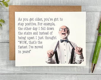May include: A humorous greeting card featuring a photo of an older man laughing and wearing a bow tie. The text on the card reads: "As you get older, you've got to stay positive. For example, the other day I fell down the stairs and instead of being upset I just thought "WOW, that's the fastest I've moved in years!"
