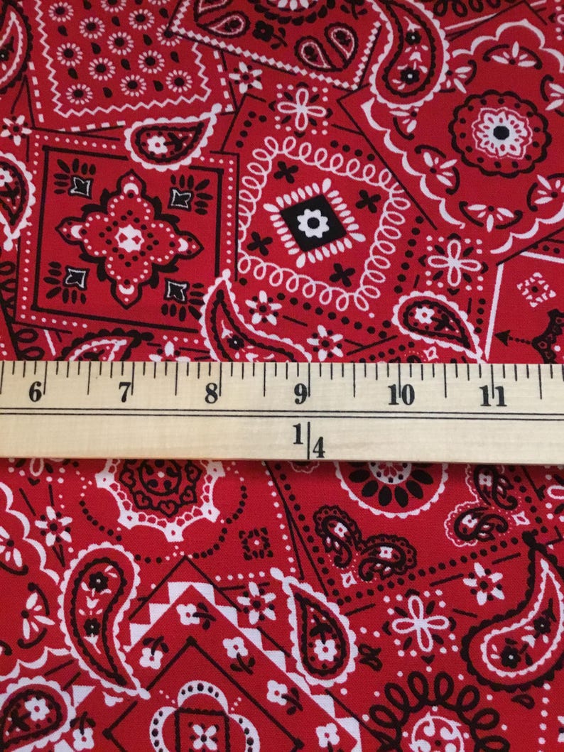May include: Red and white bandana print fabric with a ruler measuring 28.5 cm.