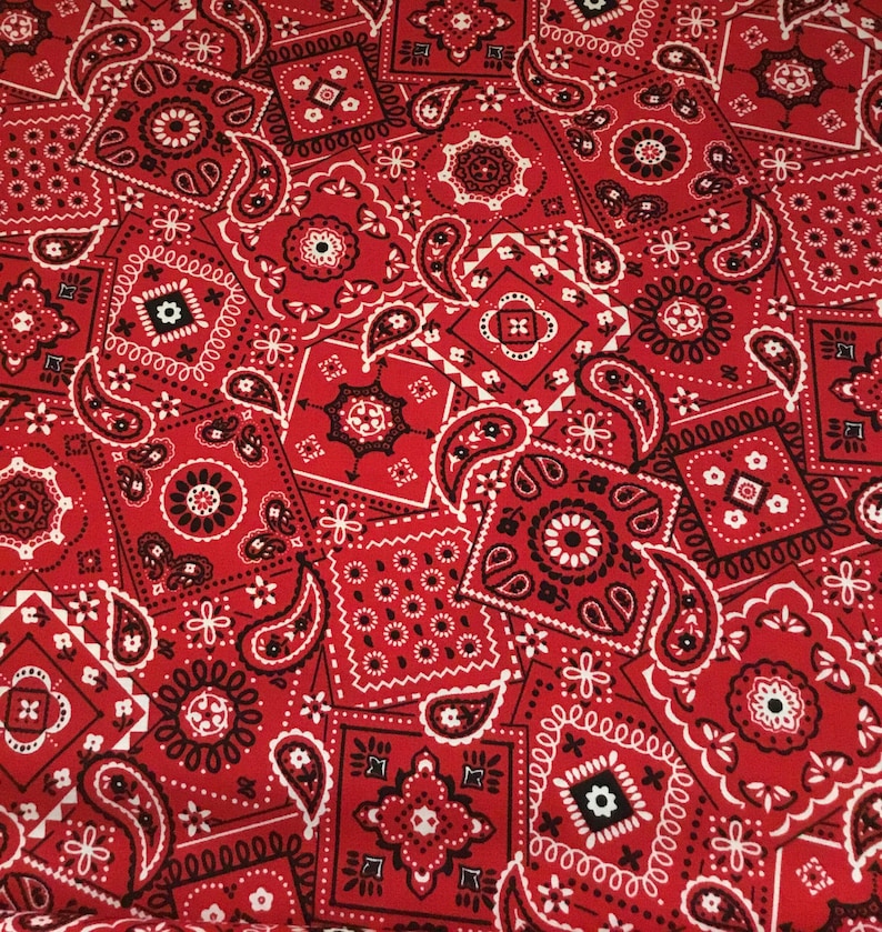 May include: Red and white bandana print fabric with a paisley pattern. The fabric is made of cotton and is ideal for quilting, crafts, and other projects.