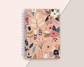 May include: A pink spiral bound notebook with a floral pattern featuring pink, red, blue, and white flowers and leaves.