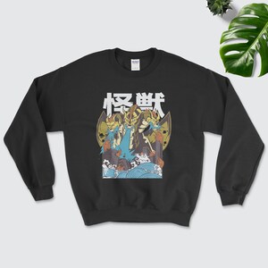 May include: Black sweatshirt featuring a graphic print of three dragons with flames and the Japanese word "怪獣" (Kaiju) in white text.