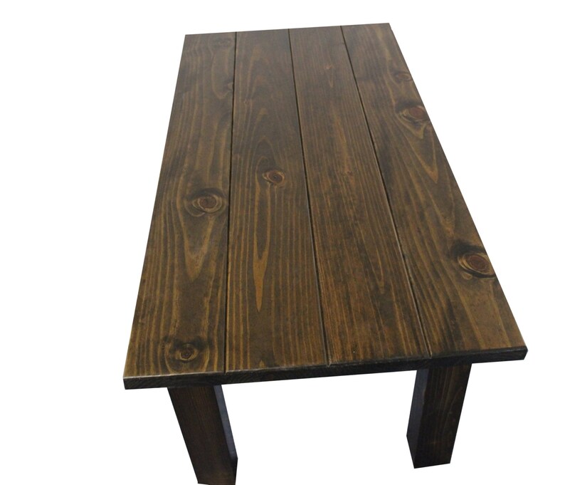 Puede incluir: Una mesa de madera marr&oacute;n oscuro con una tapa rectangular y cuatro patas. La tapa de la mesa est&aacute; hecha de tablones de madera.