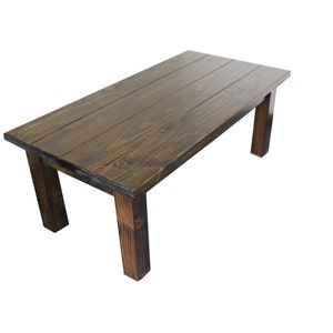 Puede incluir: Una mesa de madera marr&oacute;n oscuro con una tapa rectangular y cuatro patas. La mesa est&aacute; hecha de madera recuperada y tiene un acabado r&uacute;stico.