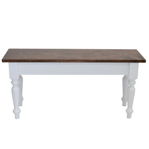 Puede incluir: Un banco de madera blanco con una tapa te&ntilde;ida de color marr&oacute;n oscuro. El banco tiene patas torneadas y un dise&ntilde;o sencillo.