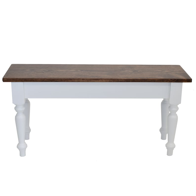 Puede incluir: Un banco de madera blanco con una tapa te&ntilde;ida de color marr&oacute;n oscuro. El banco tiene patas torneadas y un dise&ntilde;o sencillo.