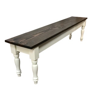 May include: A long wooden bench with a dark brown stained top and white painted legs. The legs have a turned design.