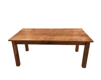 May include: A rustic wooden table with a natural brown finish. The table has a rectangular top and four sturdy legs.