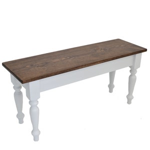 Puede incluir: Un banco de madera blanco con la parte superior te&ntilde;ida de marr&oacute;n oscuro y patas torneadas.