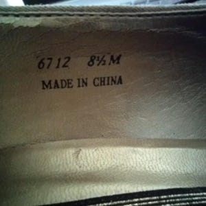 May include: Close-up of the inside of a shoe. The text "6712 8 1/2 M MADE IN CHINA" is printed in black on a light beige surface. The shoe's interior is a light beige color.