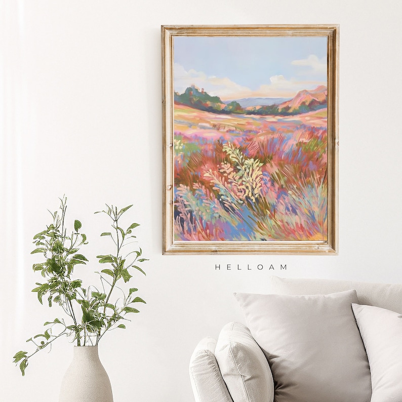 May include: A painting of a field of wildflowers in shades of pink, purple, and blue. The field is in the foreground, with a distant hillside in the background. The sky is a light blue with white clouds. The painting is framed in a gold frame.