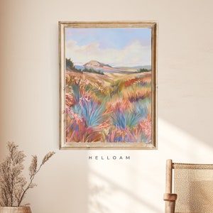 Peut inclure: Une peinture encadr&eacute;e repr&eacute;sentant un paysage avec une colline au loin et un champ de fleurs sauvages color&eacute;es au premier plan. Le ciel est bleu avec des nuages blancs. La peinture est dans un cadre dor&eacute;.