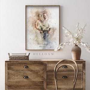 May include: A watercolor painting of a couple on their wedding day. The painting is in shades of brown, beige, and blue. The couple is standing in front of a white background. The text "The Ewong's July 3, 2022" is written below the couple.
