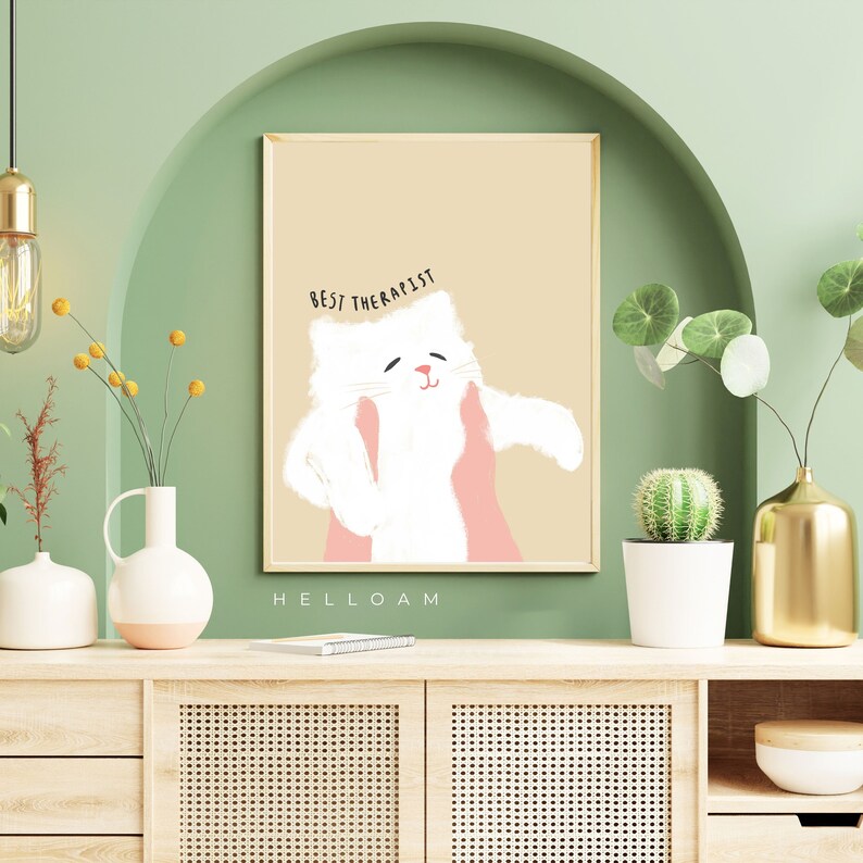 May include: A beige background with a white cat illustration. The cat is being held by two pink hands. The text "BEST THERAPIST" is above the cat. The text "HELLOAM" is below the cat.