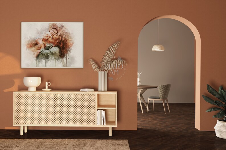 May include: A watercolor painting of a couple embracing, displayed on a wall above a light wood cabinet with a woven rattan front. The cabinet has two doors and two open shelves. A vase with dried branches sits on top of the cabinet.