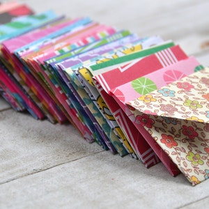 May include: A stack of colorful patterned envelopes, with a floral design on the top envelope.