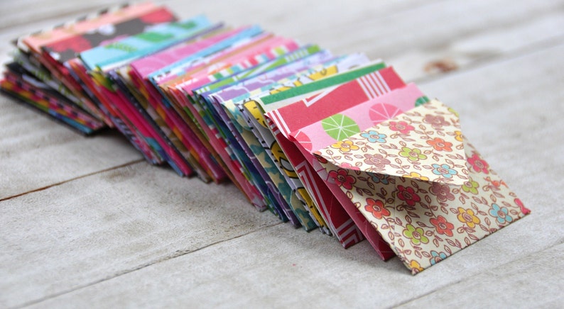May include: A stack of colorful patterned envelopes, with a floral design on the top envelope.