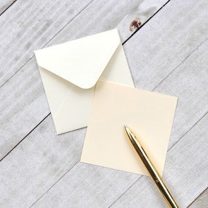 Peut inclure: Une enveloppe blanche avec un stylo dor&eacute; sur une carte de couleur cr&egrave;me. La carte est vierge et pr&ecirc;te &agrave; &ecirc;tre &eacute;crite.
