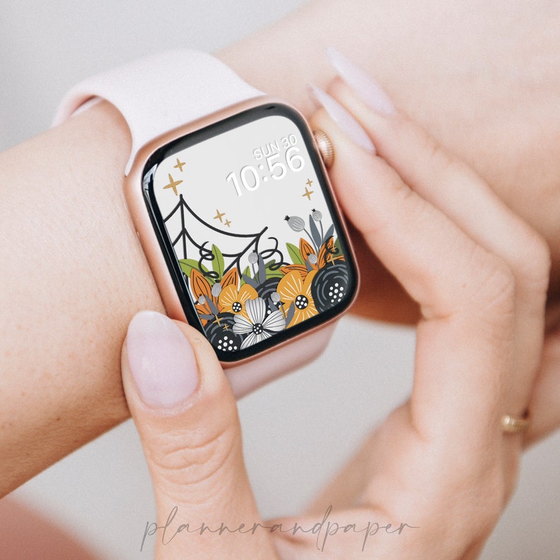 May include: A white Apple Watch with a floral and spiderweb design watch face. The watch face displays the date "SUN 30" and the time "10:56".