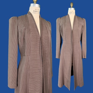 Peut inclure: Un manteau à manches longues arrivant au genou, orné d'un motif à rayures verticales marron et beige. Le vêtement présente un col châle, une taille cintrée et des épaules structurées. Le tissu alterne le sens des rayures sur les panneaux.