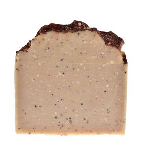 May include: A bar of brown and beige soap with a speckled texture. The soap is rectangular and has a slightly irregular shape.