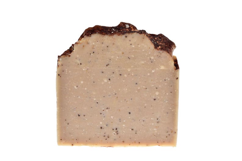 May include: A bar of brown and beige soap with a speckled texture. The soap is rectangular and has a slightly irregular shape.