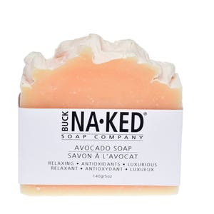 Puede incluir: Una pastilla de jab&oacute;n de aguacate de Buck Na-Ked Soap Company. El jab&oacute;n es de color melocot&oacute;n claro y tiene una etiqueta blanca con texto negro que dice "Avocado Soap, Savon &agrave; l'avocat, Relaxing, Antioxidants, Luxurious, Relaxant, Antioxydant, Luxe, 140g/5oz."