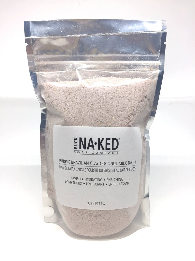 Peut inclure: Un sachet refermable argent&eacute; rempli d'un bain moussant violet. L'&eacute;tiquette indique "Buck Na-Ked Soap Company" et "Purple Brazilian Clay Coconut Milk Bath". L'&eacute;tiquette comprend &eacute;galement le texte "Lavish Hydrating Enriching" et "Somptueux Hydratant Enrichissant". Le sachet contient 389 millilitres de bain moussant.