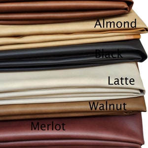May include: A stack of seven different coloured leather swatches. The swatches are labelled from top to bottom: Pecan, Almond, Black, Latte, Walnut, Merlot, and Cacao.
