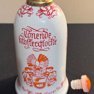Vintage German GDR Porcelain Wine Bottle With A Bell On The Bottom And A Plastic Cap. In Excellent Condition.