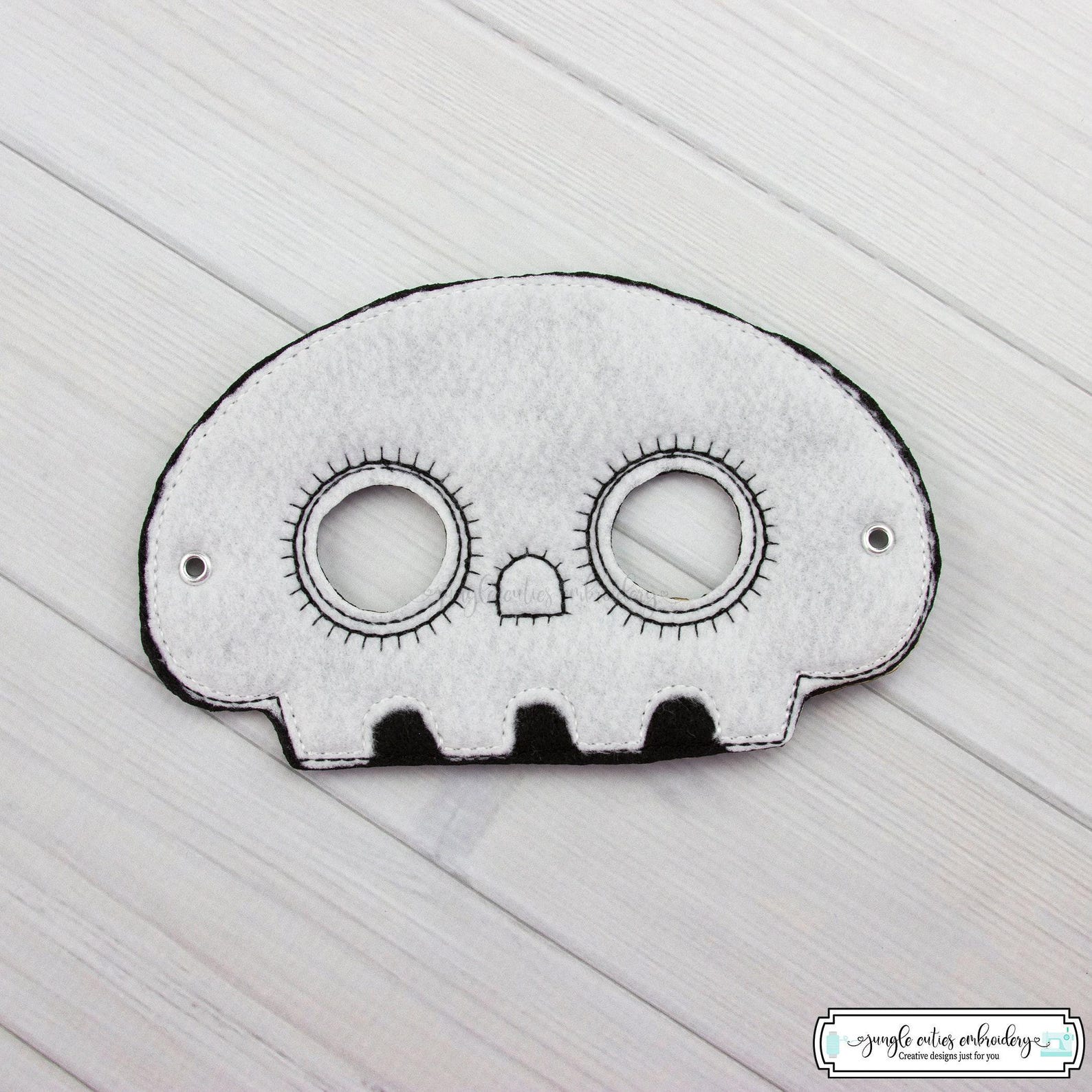 White skull felt mask with black dotted edging and small teeth.