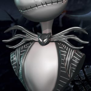 Può includere: Un busto in argento di Jack Skellington del film L'incubo prima di Natale. Il busto indossa un abito a righe bianche e nere con un papillon nero a forma di gatto. Il busto è su una base di legno con le parole "Tim Burton" incise.