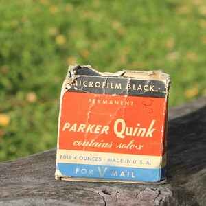 May include: Vintage Parker Quink Microfilm Black ink box. The box is red, blue, and white with the words "PARKER Quink" prominently displayed. The box contains 4 fluid ounces and is made in the U.S.A. The box is slightly worn.