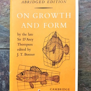 May include: An orange book cover with the title "On Growth and Form" by the late Sir D'Arcy Thompson, edited by J.T. Bonner. The cover features two black and white illustrations of fish within grid patterns.