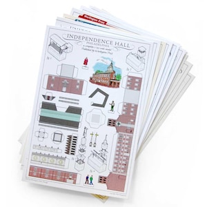 May include: A stack of paper sheets featuring a paper model kit of Independence Hall in Philadelphia, published by Wurlington Press. The top sheet displays printed architectural components, a colored illustration of the building, and small figures.