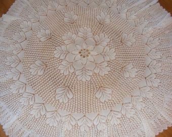 May include: White crocheted tablecloth with a delicate floral design in the centre.