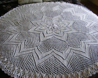 May include: A white crocheted blanket with a starburst pattern in the centre.
