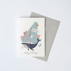 May include: A blue and white birthday card featuring a whale, octopus and crab. The number 4 is in the background with the name Spencer on a banner. The card reads "Happy Birthday".