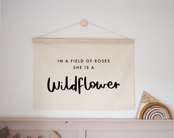 In A Field Of Roses, She Is A Wildflower Wall Hanging - Choose your own vinyl colour 70x50cm - now with eyelets option