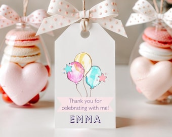 May include: A white tag with a pink ribbon tied around it. The tag has a drawing of colourful balloons and the text "Thank you for celebrating with me! EMMA".
