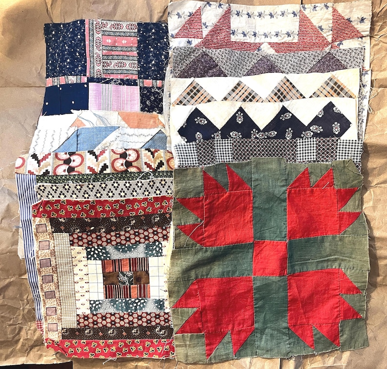 May include: A collection of antique quilt blocks in various patterns and colors. The blocks feature patchwork designs with floral, geometric, and striped fabrics. One block has a red bear paw design on a green background.