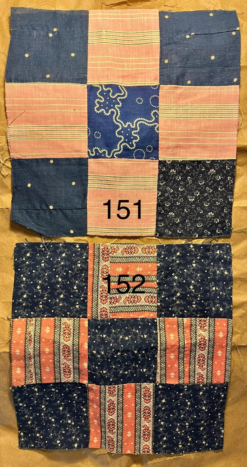 May include: Two patchwork quilt squares with a variety of fabric patterns. The squares feature navy blue, pink, and patterned fabrics. One square has the number "151" and the other has "152" printed on it. The fabrics have floral, striped, and dotted designs.
