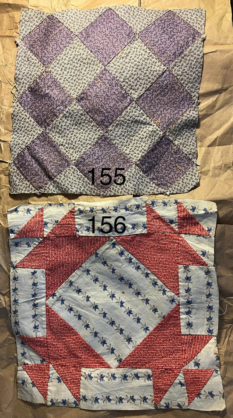 May include: Two antique quilt squares. The top square features a diamond pattern in lavender and gray. The bottom square has a red and white design with blue floral accents. Both squares have the numbers 155 and 156 printed on them.
