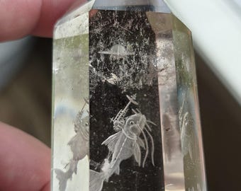 cat fish with a freaking laser on its head reverse intaglio carved onto a polished quartz crystal tower