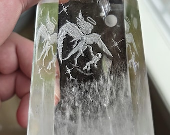 Angel saving an astronaut reverse intaglio carved onto a polished quartz crystal tower