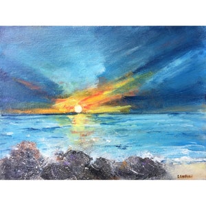 May include: A painting of a sunset over the ocean. The sky is a deep blue with streaks of orange and yellow. The sun is setting in the distance, and the water is a calm blue. There are rocks in the foreground.
