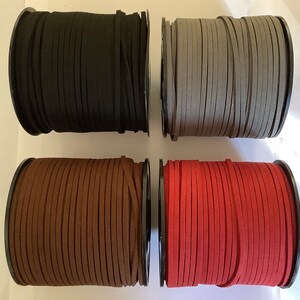 May include: Four spools of suede cord in black, grey, brown, and red. Each spool is wound with the cord and has a black plastic centre.