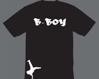 Puede incluir: Camiseta negra con texto blanco que dice "B-BOY" y una silueta blanca de una persona bailando breakdance en la esquina inferior derecha.